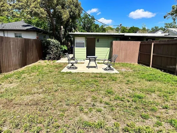 a backyard of a house with table and chairs