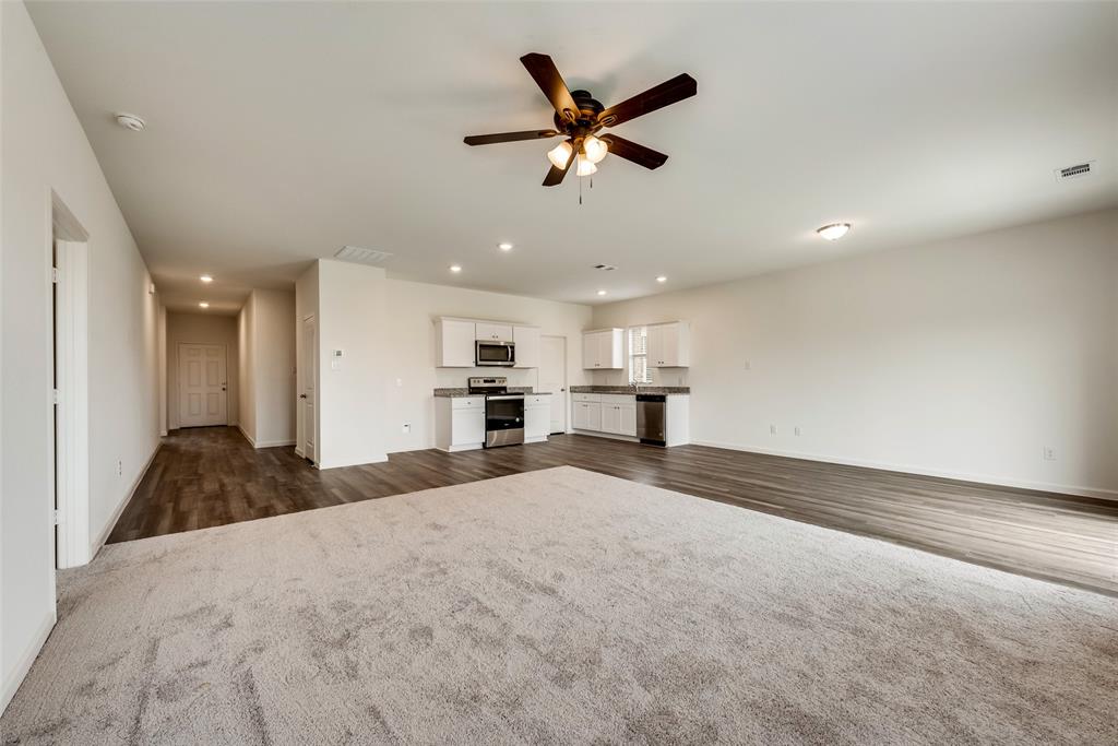 1608 Escondido Drive Haslet, TX 76052 - Photo 8 of 20 a view of a livingroom with a ceiling fan and kitchen view