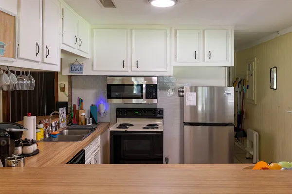 a kitchen with stainless steel appliances granite countertop a refrigerator stove and white cabinets