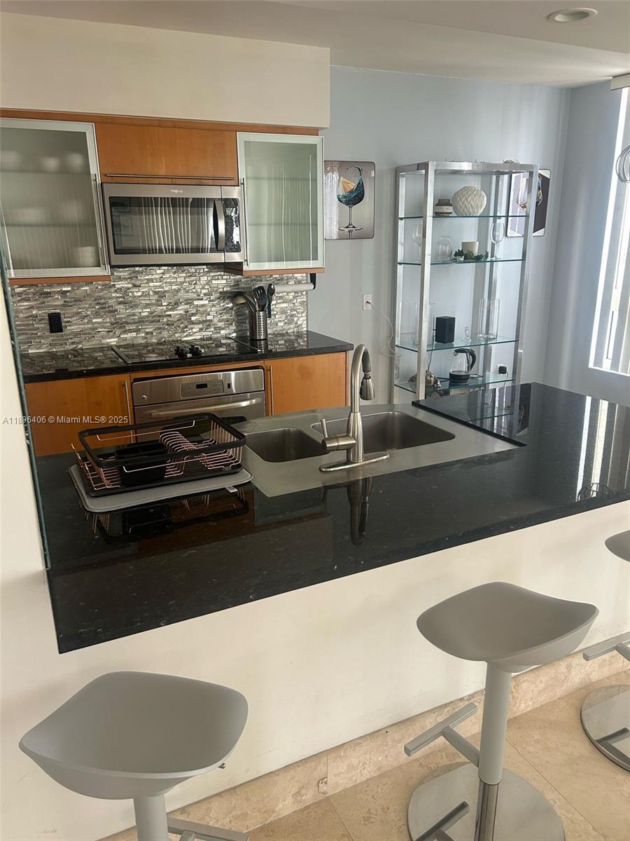 6365 Collins Avenue, Unit 1508 Miami Beach, FL 33141 - Photo 11 of 18 a kitchen with a stove and a refrigerator