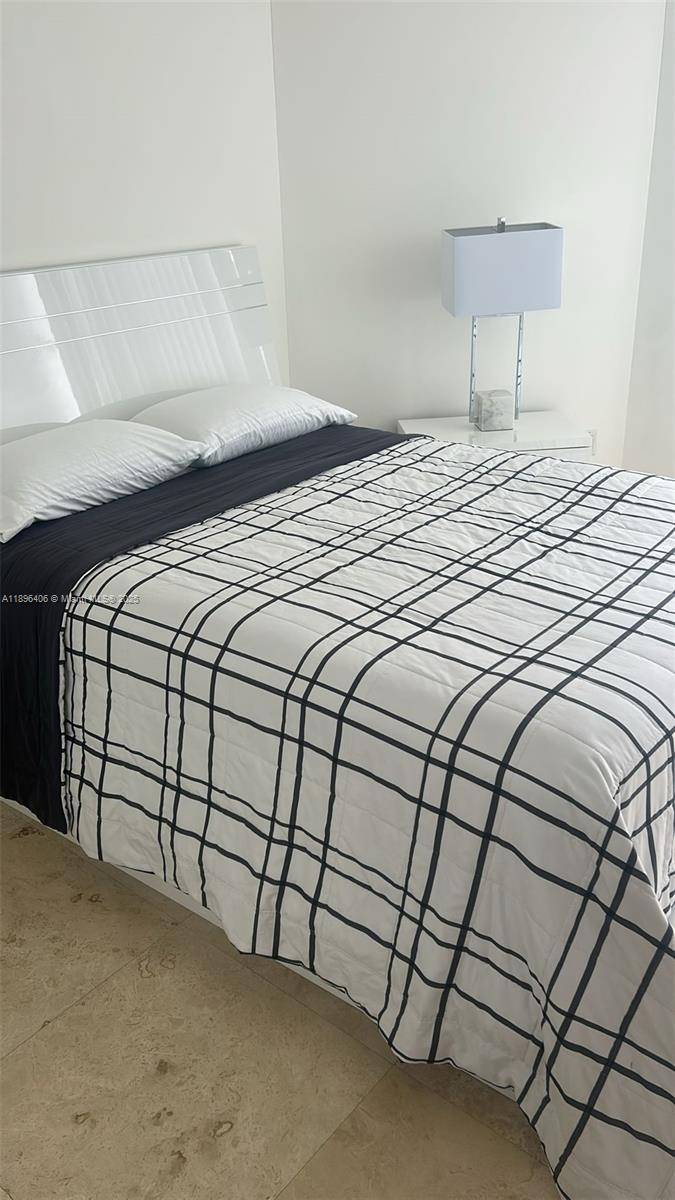 6365 Collins Avenue, Unit 1508 Miami Beach, FL 33141 - Photo 12 of 18 a bedroom with a bed and a night stand