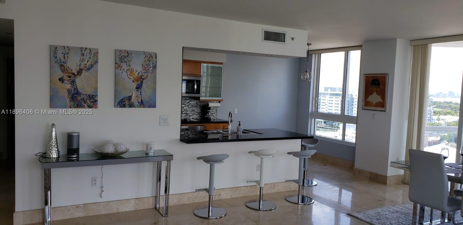 6365 Collins Avenue, Unit 1508 Miami Beach, FL 33141 - Photo 3 of 18 a kitchen with stainless steel appliances a sink a window and cabinets