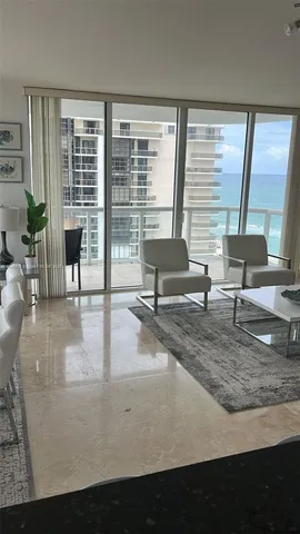 a view of living room with furniture and large windows