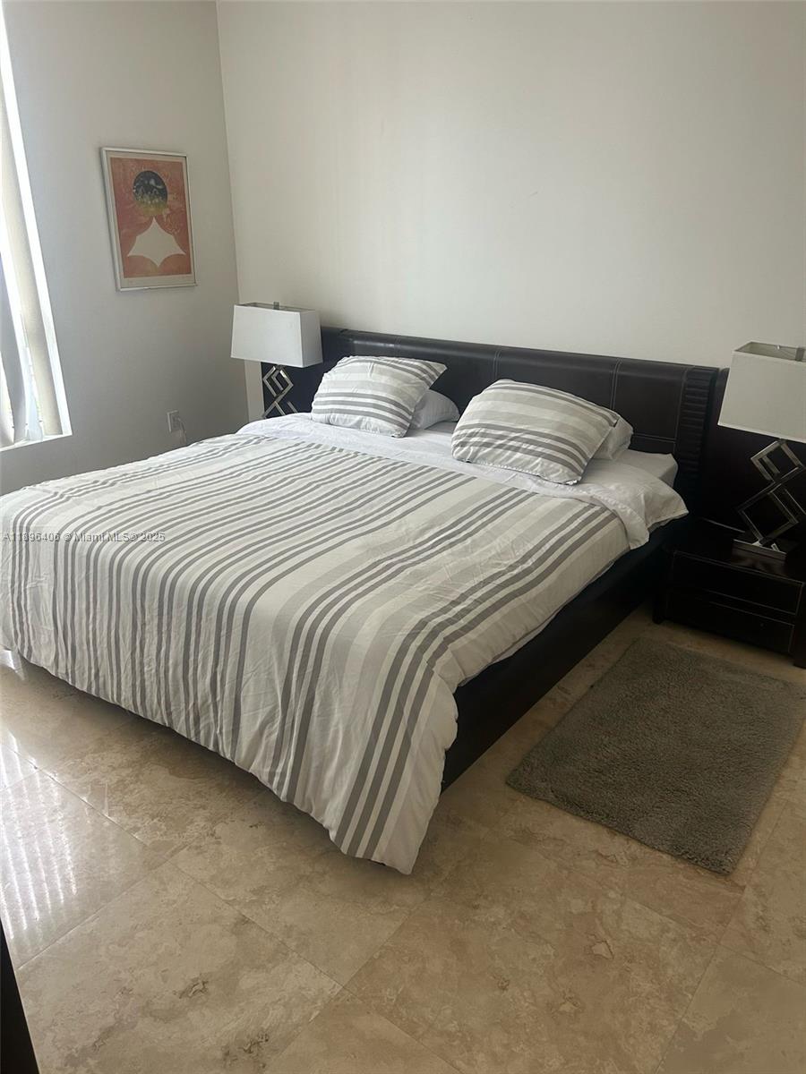 6365 Collins Avenue, Unit 1508 Miami Beach, FL 33141 - Photo 9 of 18 a bedroom with bed and a night stand