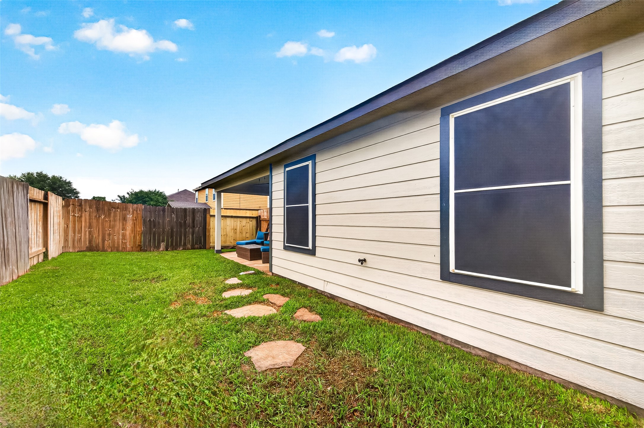 3155 View Valley Trail Katy, TX 77493 - Photo 48 of 50 Extensive side yard view highlighting the pristine exterior siding, stone walkway, and secure fencing