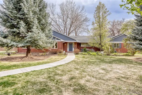 a view of a house with a yard and large tree