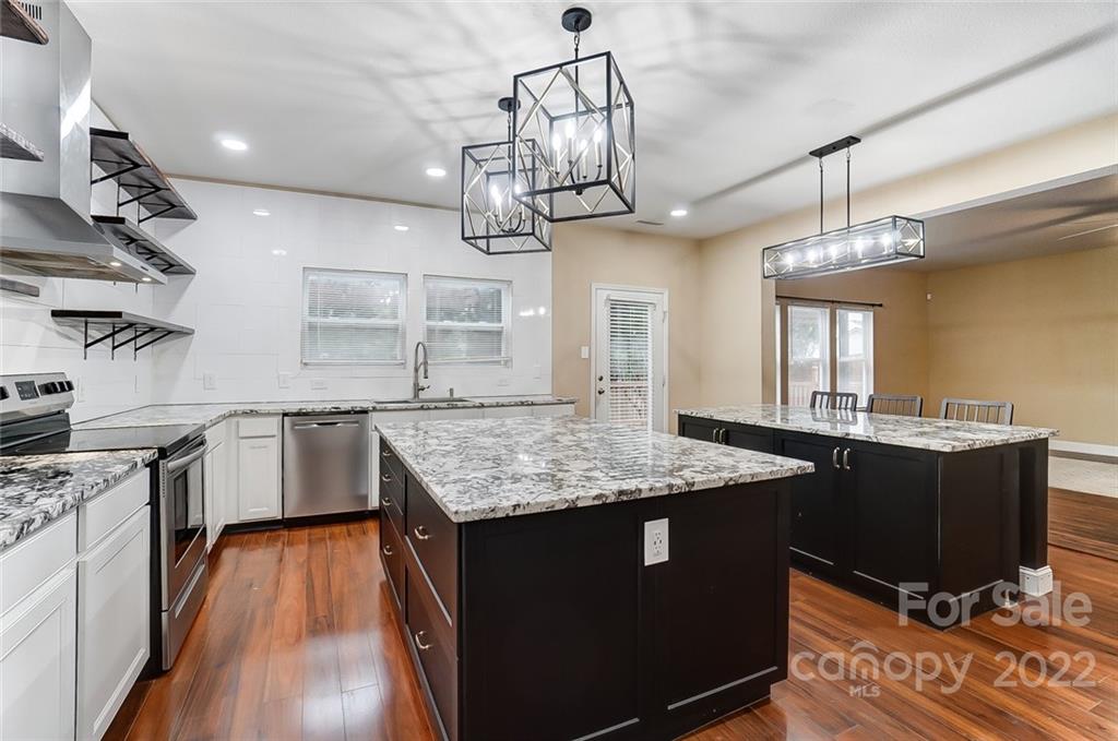 207 Old Carriage Road Clover, SC 29710 - Photo 14 of 48 a kitchen with stainless steel appliances granite countertop a sink dishwasher a stove and a dining table with wooden floor