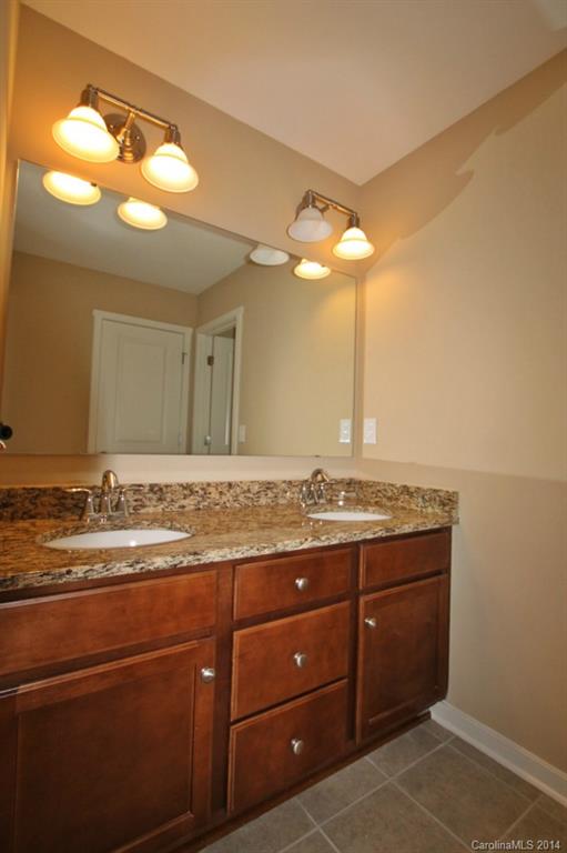 2186 Bluebell Way, Unit 170 Tega Cay, SC 29708 - Photo 15 of 15 a bathroom with a granite countertop sink a light fixture and a mirror
