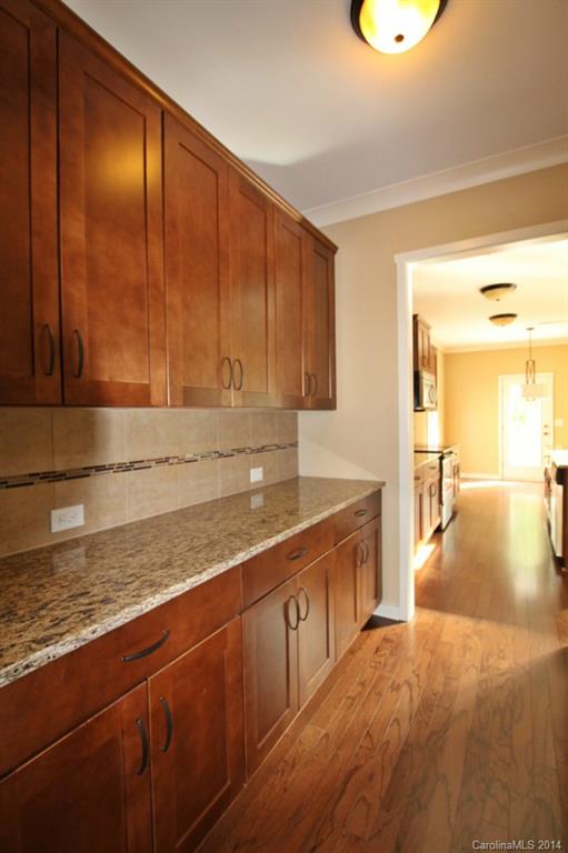 2186 Bluebell Way, Unit 170 Tega Cay, SC 29708 - Photo 4 of 15 a kitchen with stainless steel appliances granite countertop a sink a stove cabinets and wooden floor