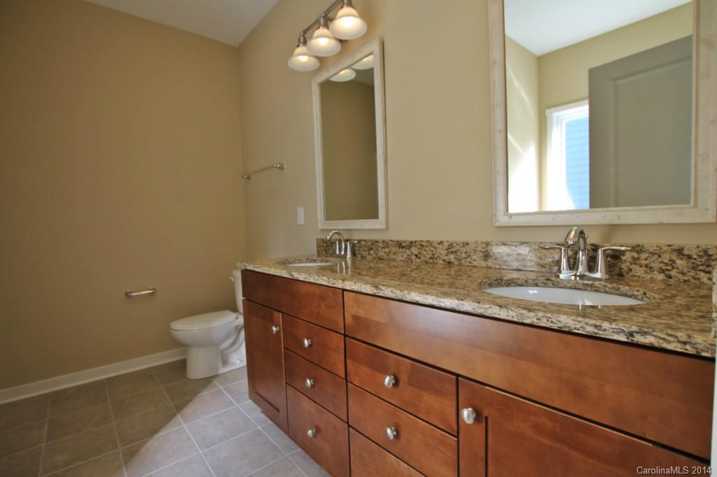 2186 Bluebell Way, Unit 170 Tega Cay, SC 29708 - Photo 10 of 15 a bathroom with a granite countertop sink a toilet and a mirror