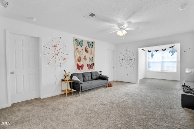 a living room with furniture and a ceiling fan