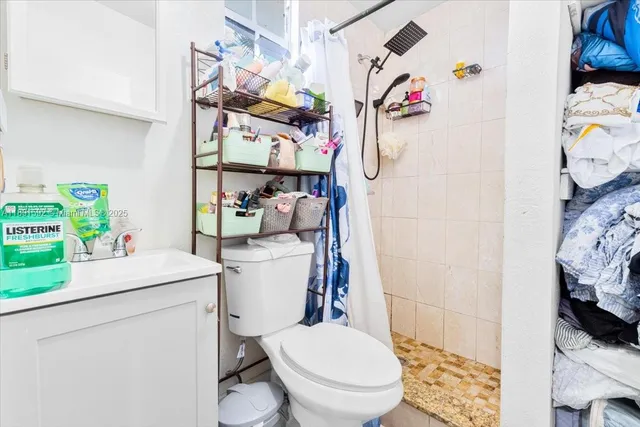 a bathroom with a sink a toilet and a shower curtain
