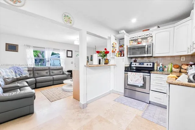 a living room with furniture and a kitchen view