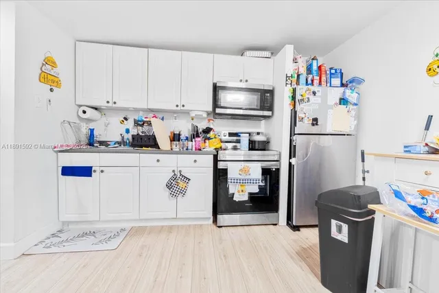 a kitchen with stainless steel appliances a refrigerator sink and cabinets