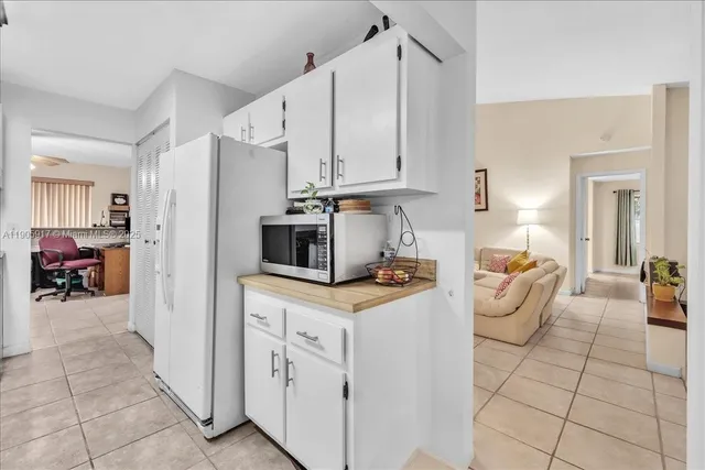 a kitchen with stainless steel appliances kitchen island granite countertop a refrigerator and a sink