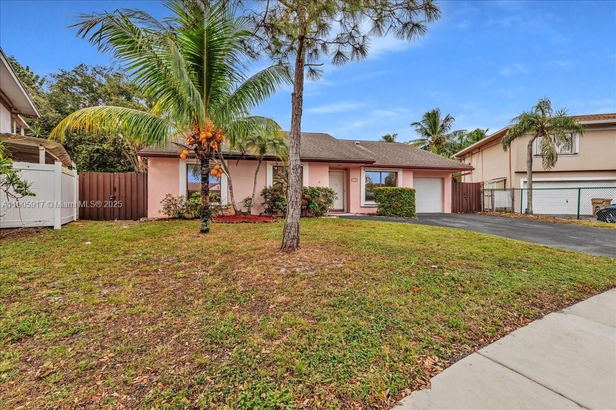 3930 Northwest 79th Way Davie, FL 33024 - Photo 31 of 33 a front view of a house with a garden and palm trees