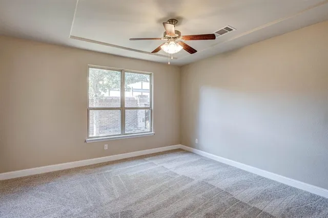 an empty room with a window and a fan
