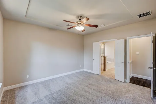 an empty room with closet and a ceiling fan