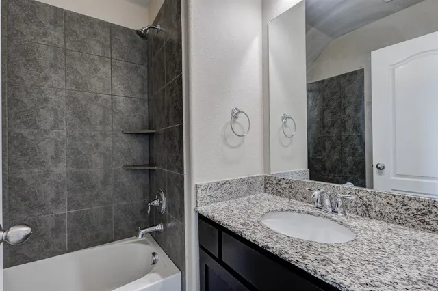 a bathroom with a granite countertop sink a toilet and bathtub