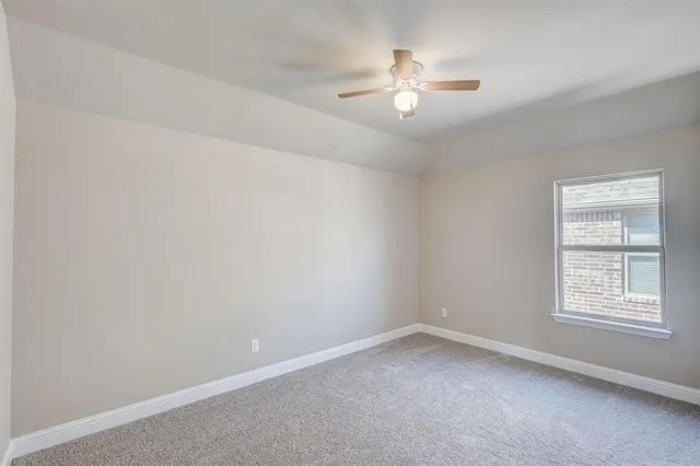en empty room with windows and chandelier fan
