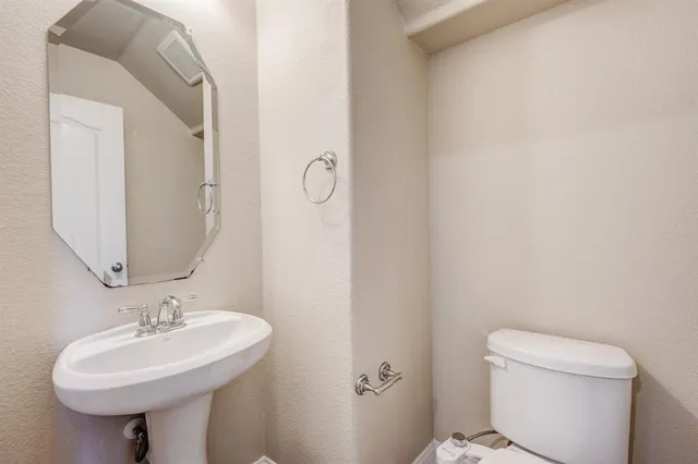 a bathroom with a sink a toilet and mirror