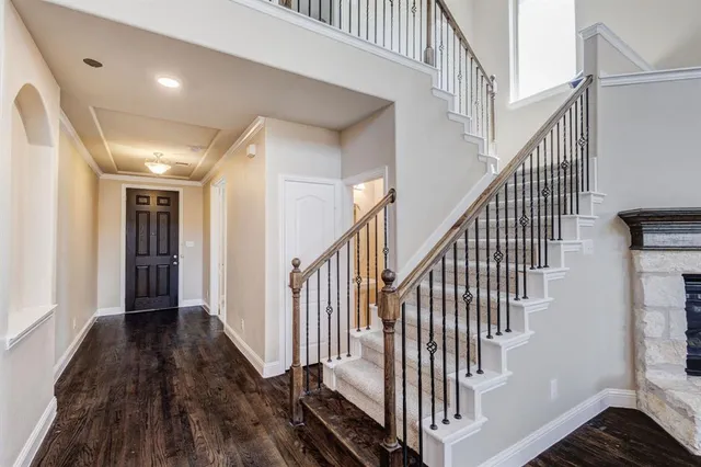 a view of a hallway with wooden floor and staircase