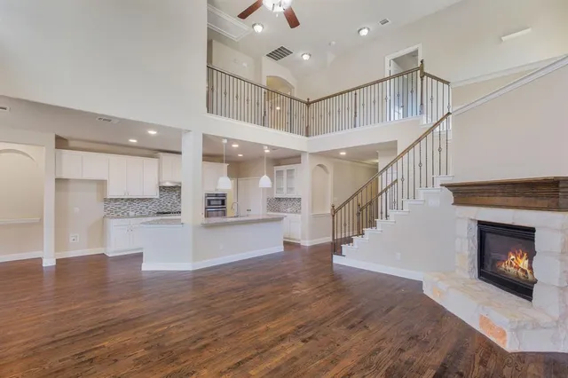 a view of a room with wooden floor and a kitchen