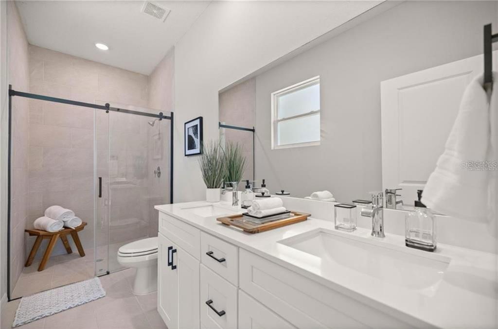 5550 Southwest 107th Street Ocala, FL 34476 - Photo 13 of 17 a bathroom with a granite countertop sink a toilet and shower