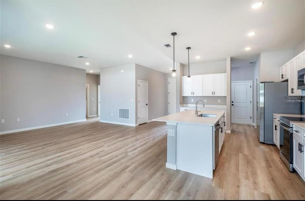 5550 Southwest 107th Street Ocala, FL 34476 - Photo 5 of 17 a large kitchen with stainless steel appliances a large counter top a sink a refrigerator and a stove