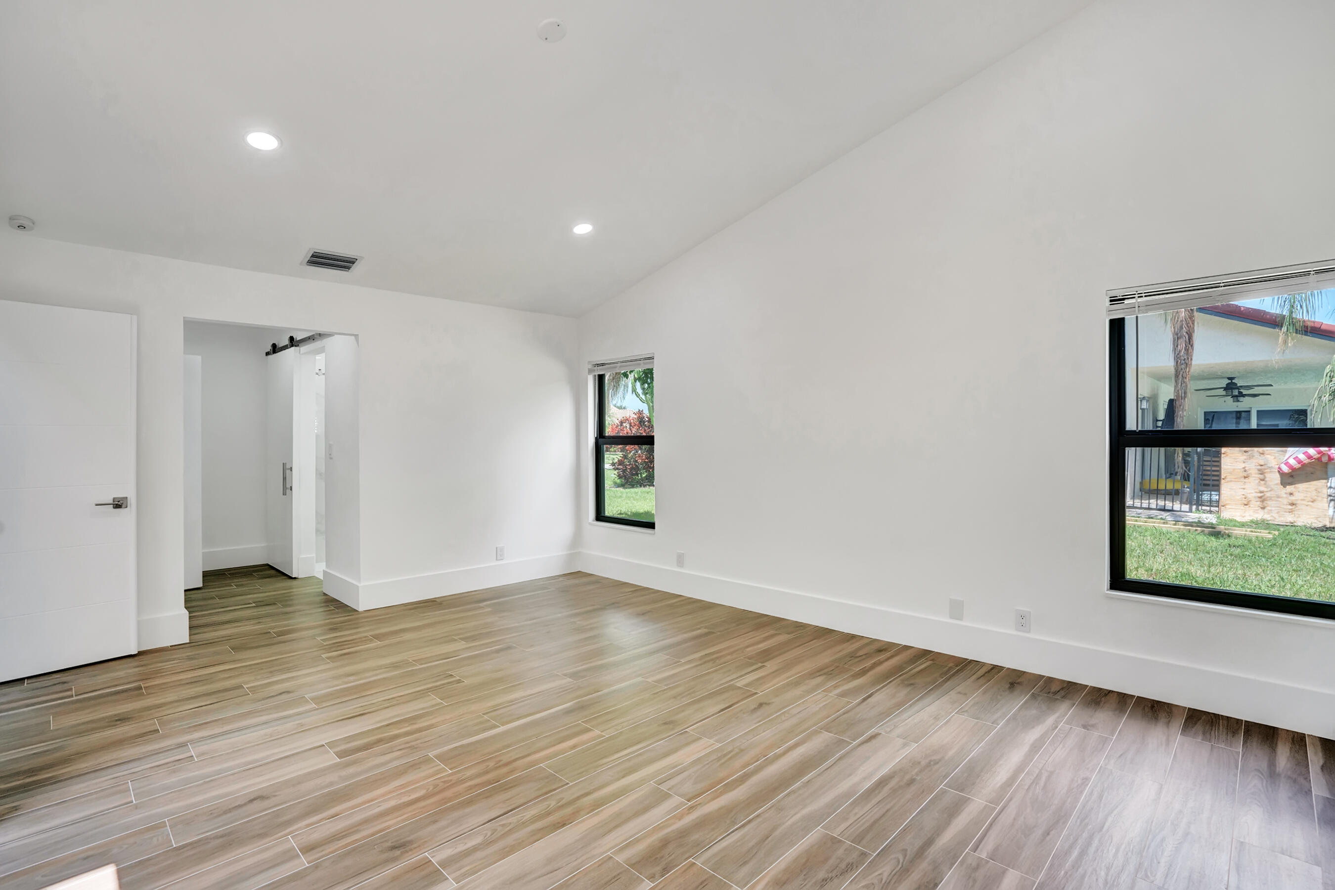 21075 Madria Circle Boca Raton, FL 33433 - Photo 13 of 29 a view of an empty room with wooden floor and a window