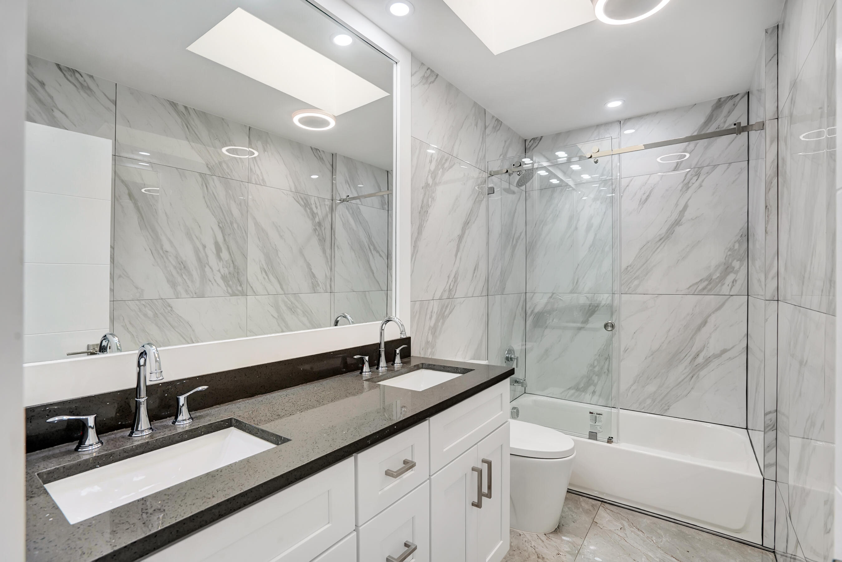21075 Madria Circle Boca Raton, FL 33433 - Photo 17 of 29 a bathroom with a double vanity sink toilet mirror and shower