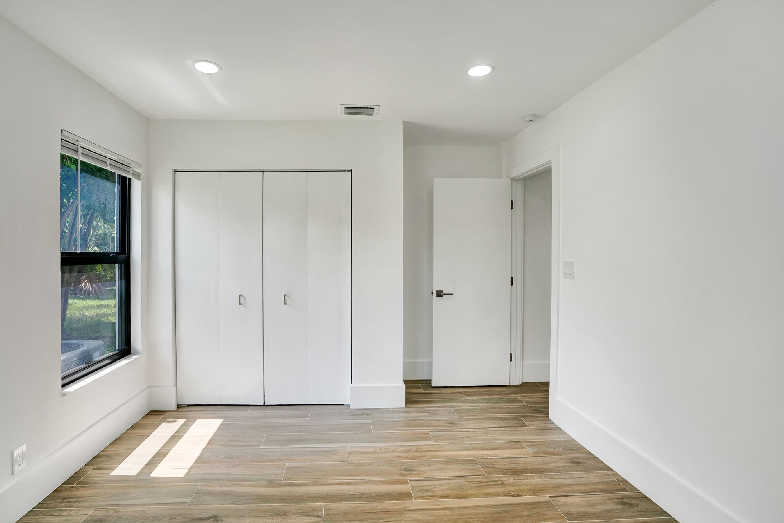 21075 Madria Circle Boca Raton, FL 33433 - Photo 9 of 29 a view of an empty room with window and wooden floor
