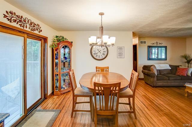 9514 State Route 143 Edwardsville, IL 62025 - Photo 5 of 29 a view of dining room and livingroom with furniture wooden floor a chandelier