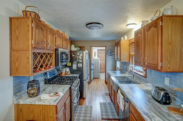 9514 State Route 143 Edwardsville, IL 62025 - Photo 8 of 29 a kitchen with sink refrigerator and stove