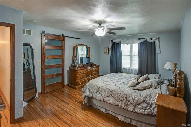 9514 State Route 143 Edwardsville, IL 62025 - Photo 9 of 29 a bedroom with a bed and a chandelier