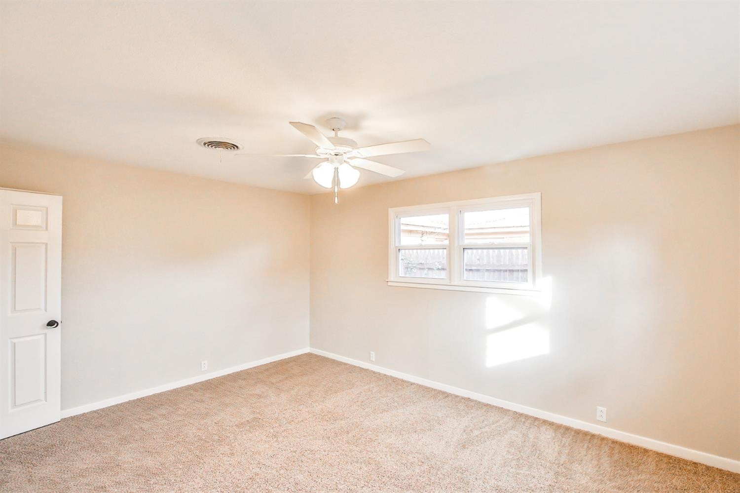 4403 49th Street Lubbock, TX 79414 - Photo 5 of 10 an empty room with windows and fan