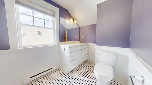 a bathroom with a granite countertop toilet a sink a mirror and a shower