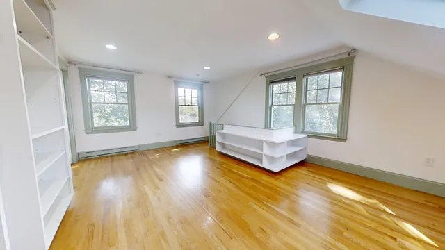 a spacious bedroom with a bed and wooden floor