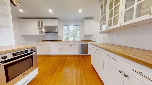 a large kitchen with stainless steel appliances granite countertop a stove and a sink