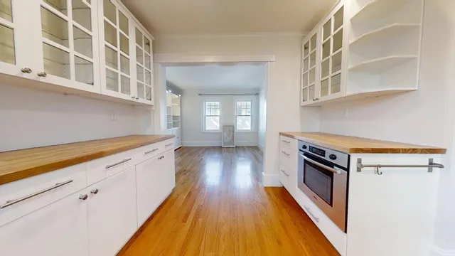 a view of a kitchen with wooden floor and cabinets