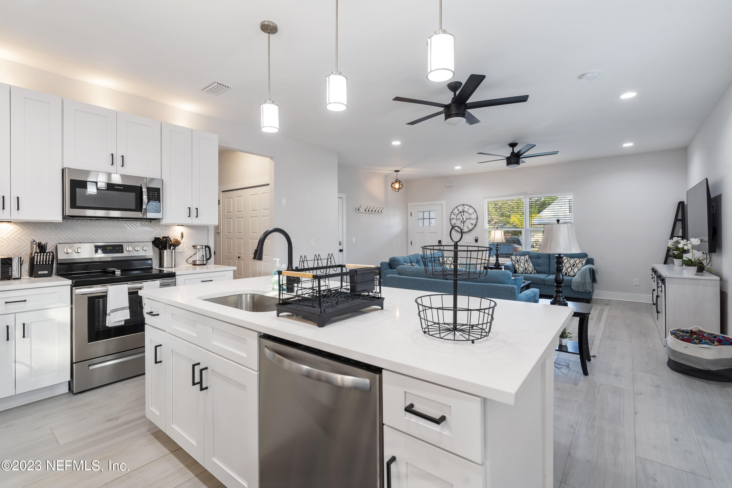 310 3rd Street St. Augustine, FL 32084 - Photo 12 of 46 a kitchen with stainless steel appliances a sink a stove a refrigerator and chairs