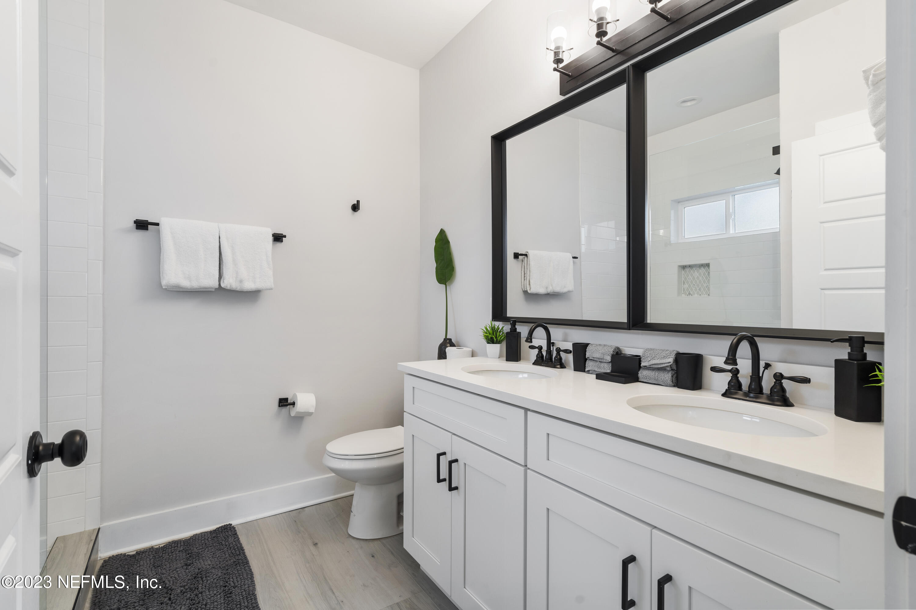 310 3rd Street St. Augustine, FL 32084 - Photo 20 of 46 a bathroom with a sink a toilet a mirror and shower curtain