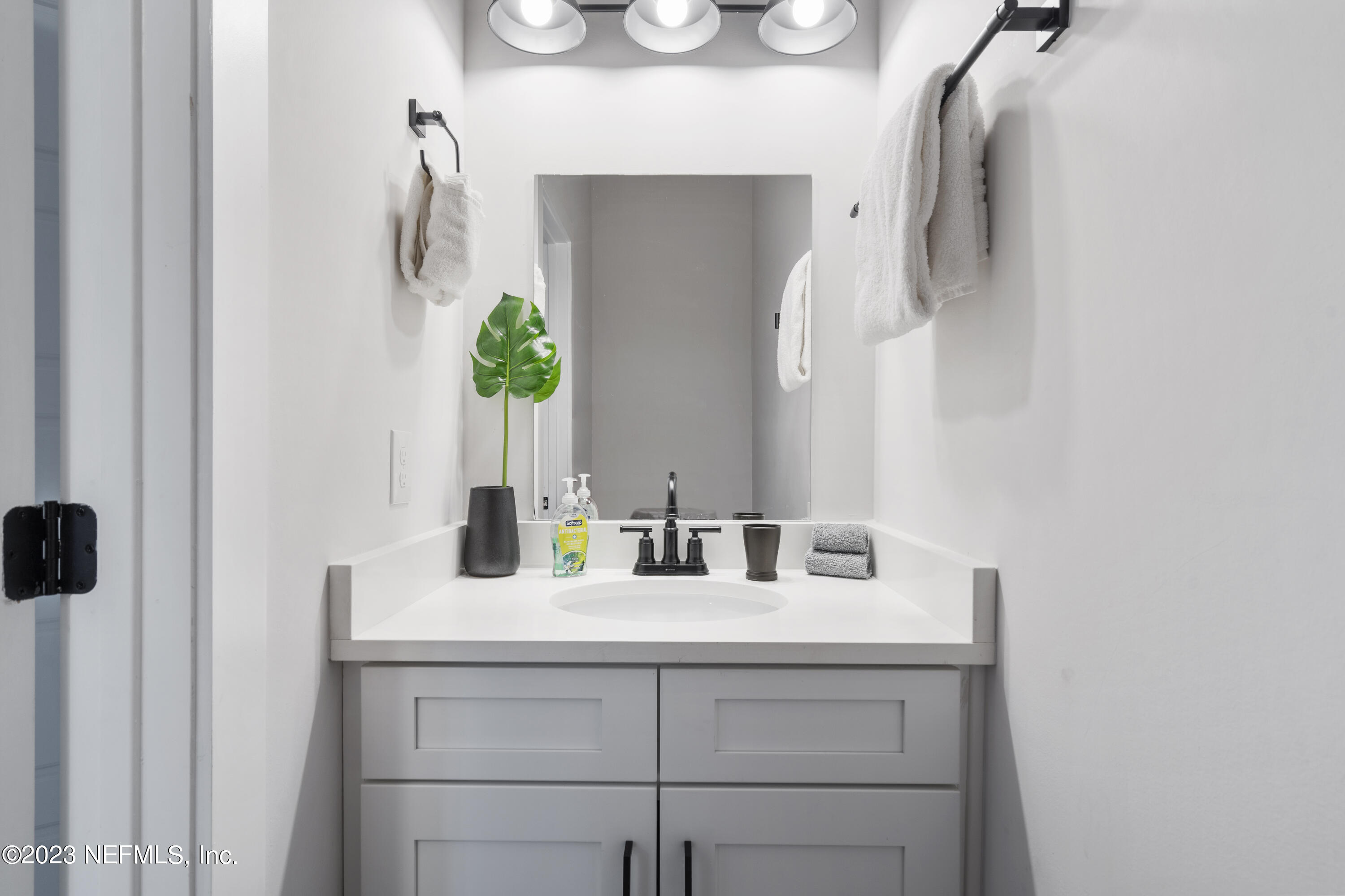 310 3rd Street St. Augustine, FL 32084 - Photo 32 of 46 a bathroom with a sink and a mirror