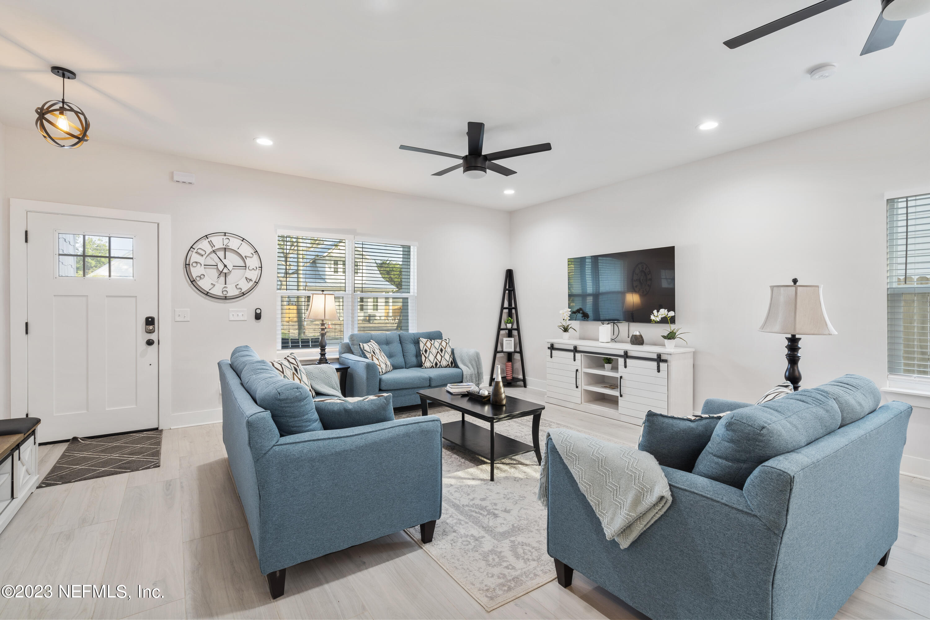310 3rd Street St. Augustine, FL 32084 - Photo 8 of 46 a living room with furniture a clock and a flat screen tv