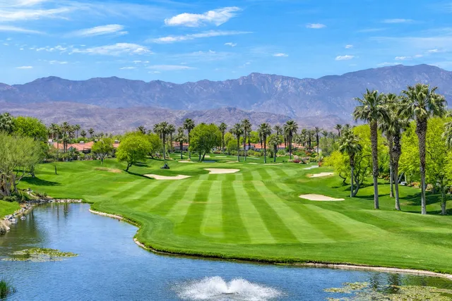 a view of grassy field with mountains in the background