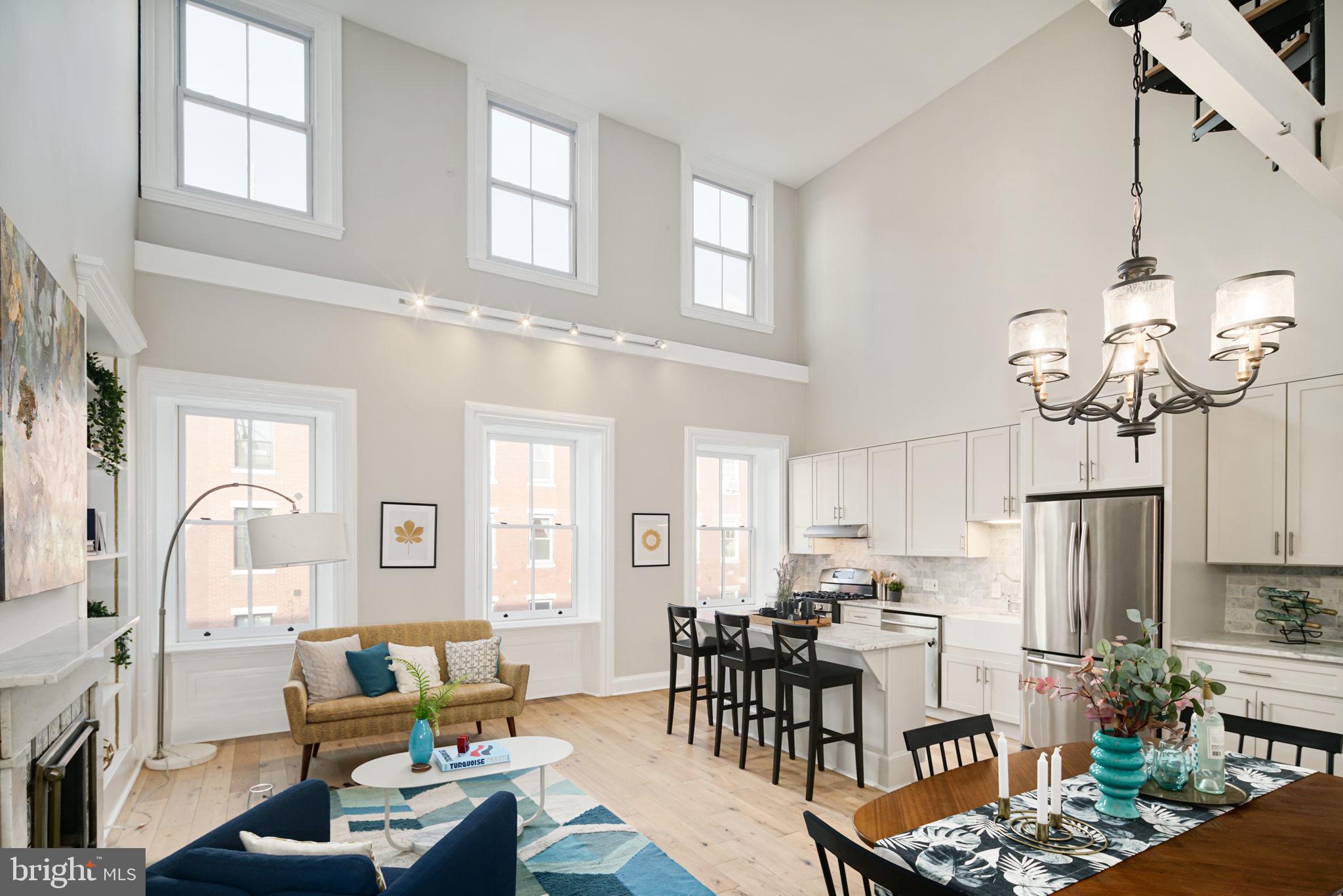 a living room with furniture a fireplace and a chandelier