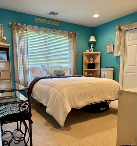 a bed sitting in a bedroom next to a window