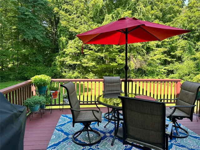 a view of a patio with table and chairs under an umbrella