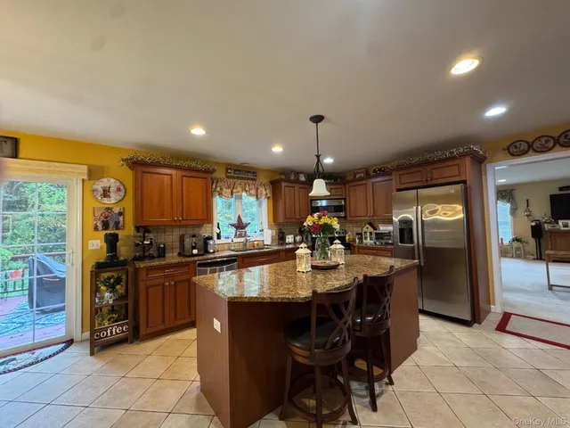 a kitchen with stainless steel appliances granite countertop a refrigerator a sink a stove and island