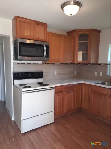 a kitchen with granite countertop a stove microwave and sink